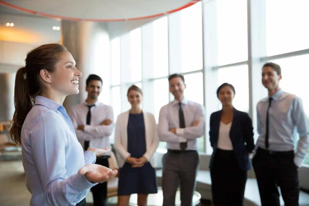 Uma mulher em um cargo de liderança se comunica com sua equipe.