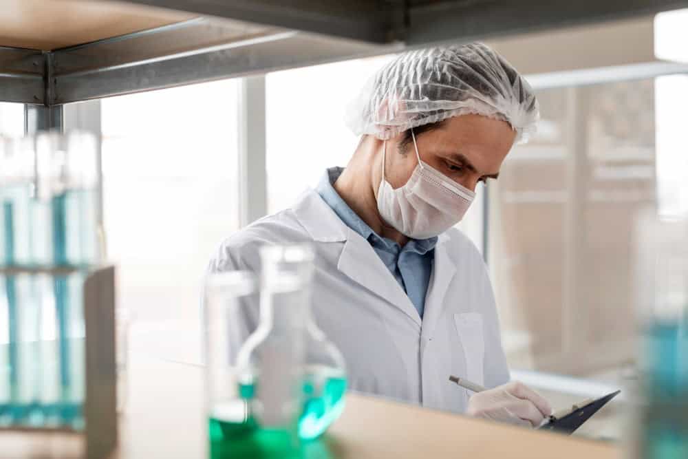 Cientista faz anotações em sua prancheta.